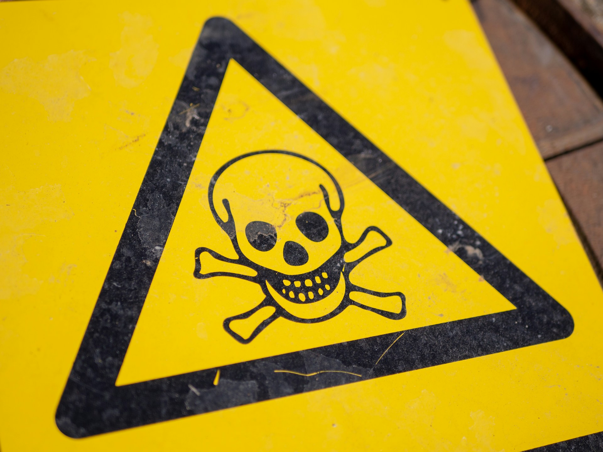 A yellow warning sign with a skull and crossbones.
