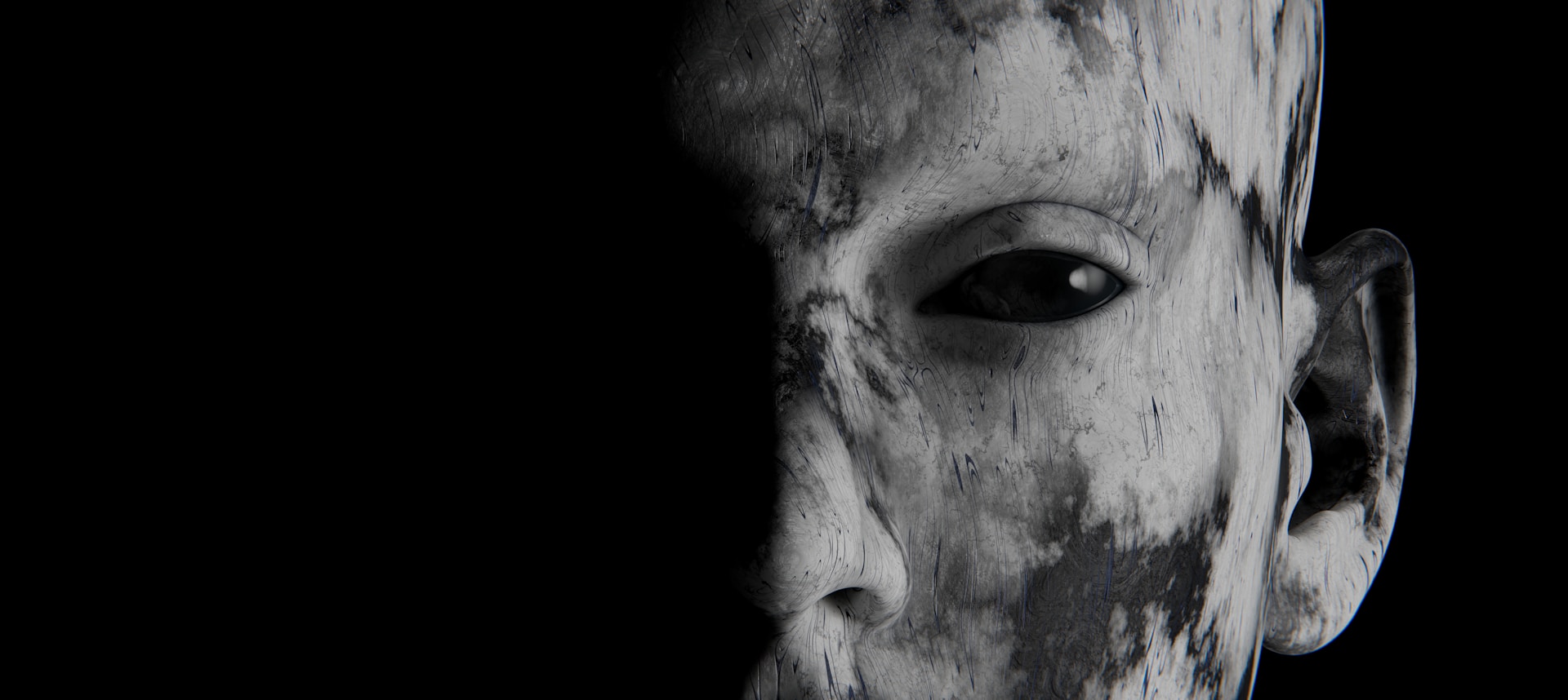 A human face half in shadow. The skin is dirty and the only visible eye appears to be completely black.