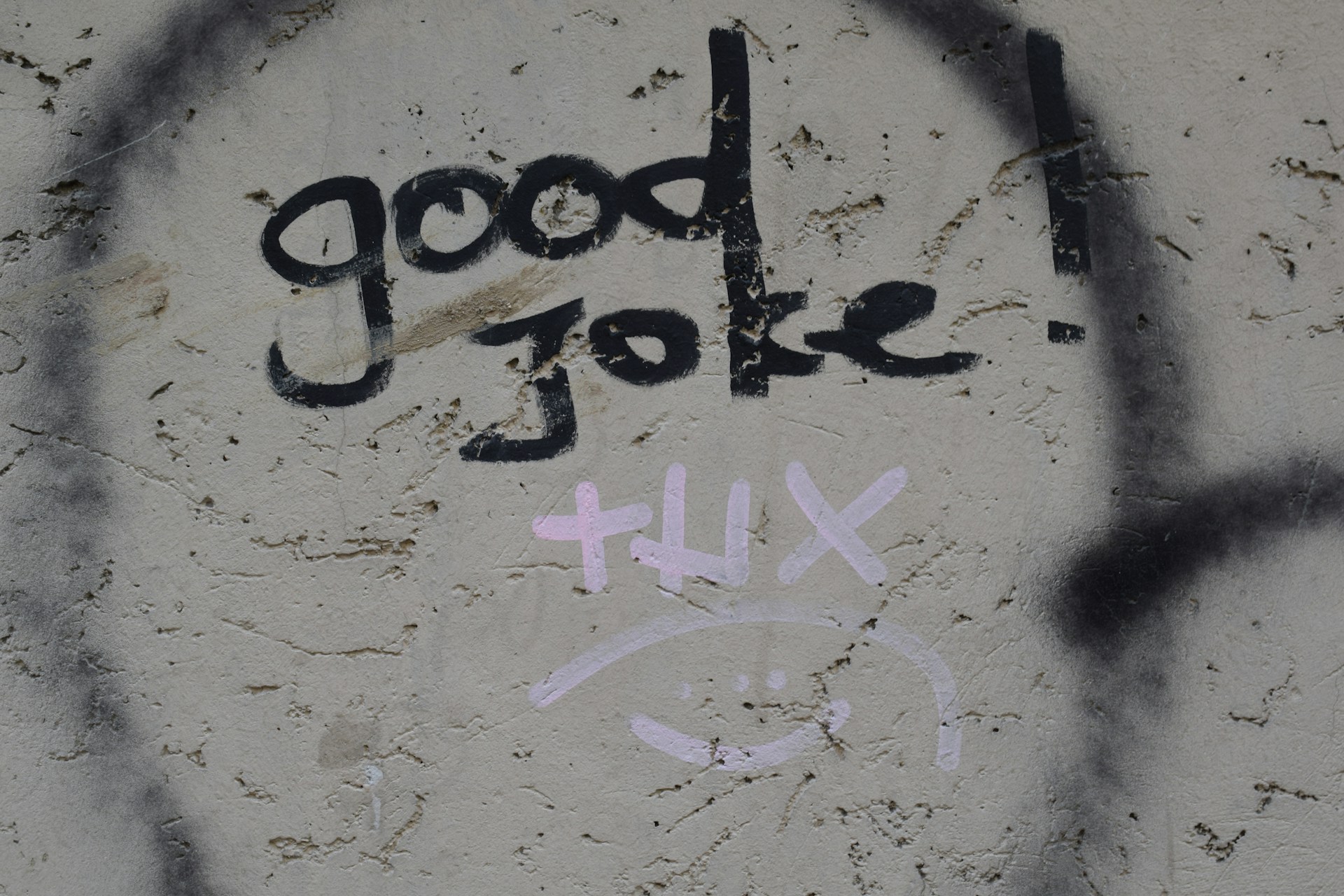 A concrete wall with graffiti reading