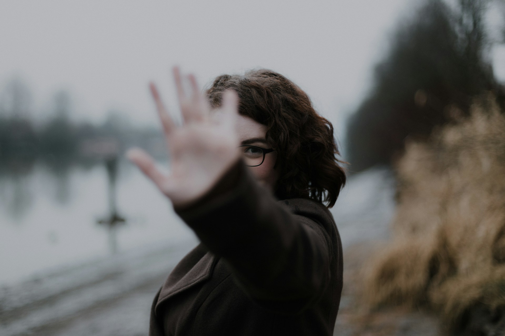 A person holds up an open palm, gesturing