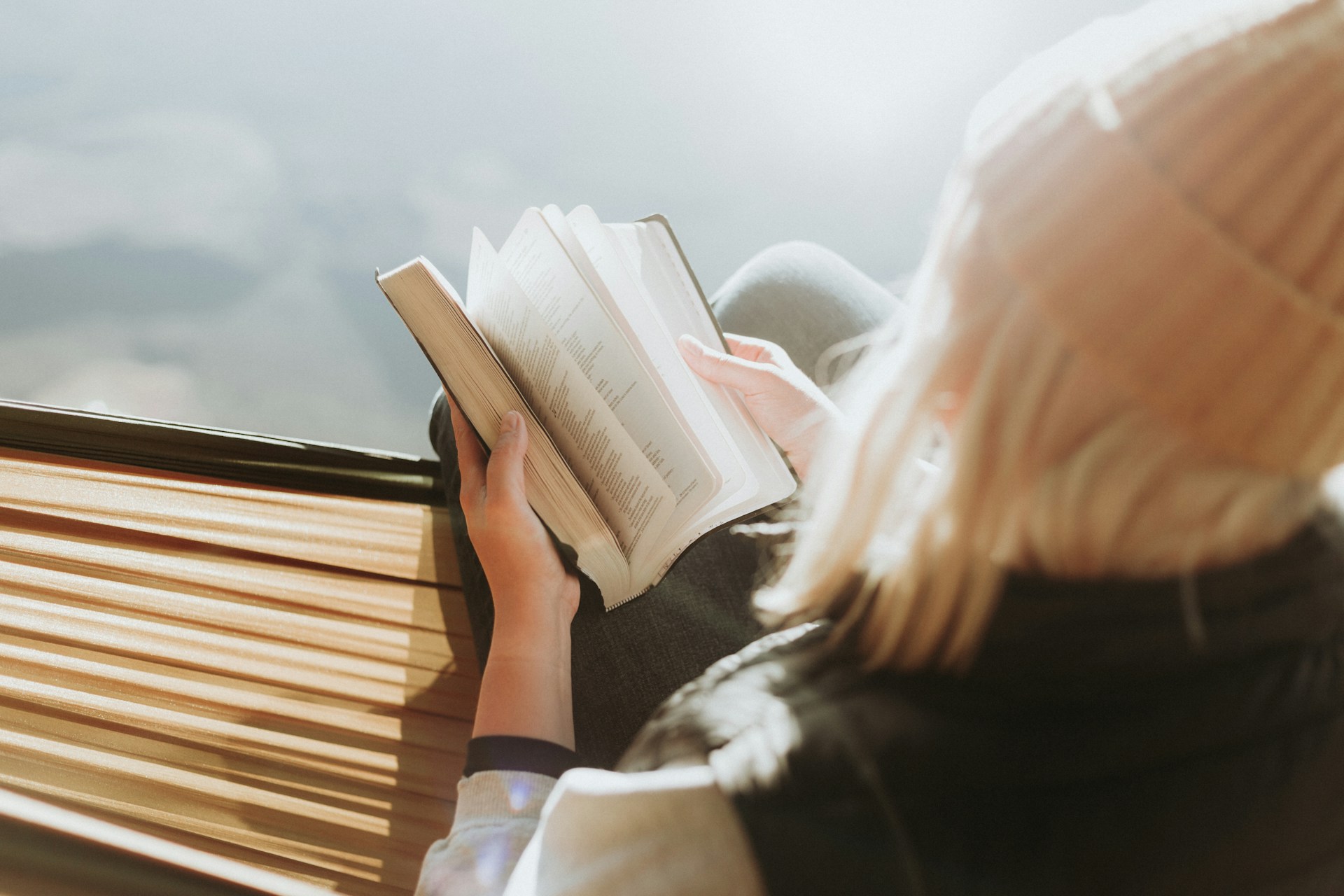 A person in a beanie flips through a book.