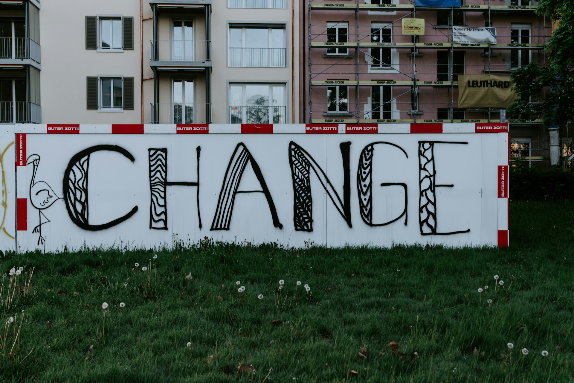 A big sign in front of an apartment building reads