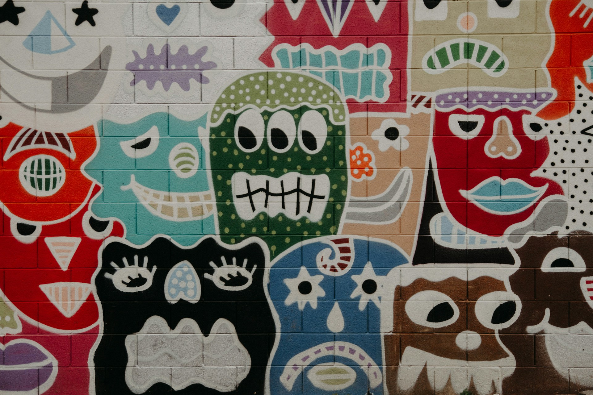 Silly faces painted onto a brick wall.
