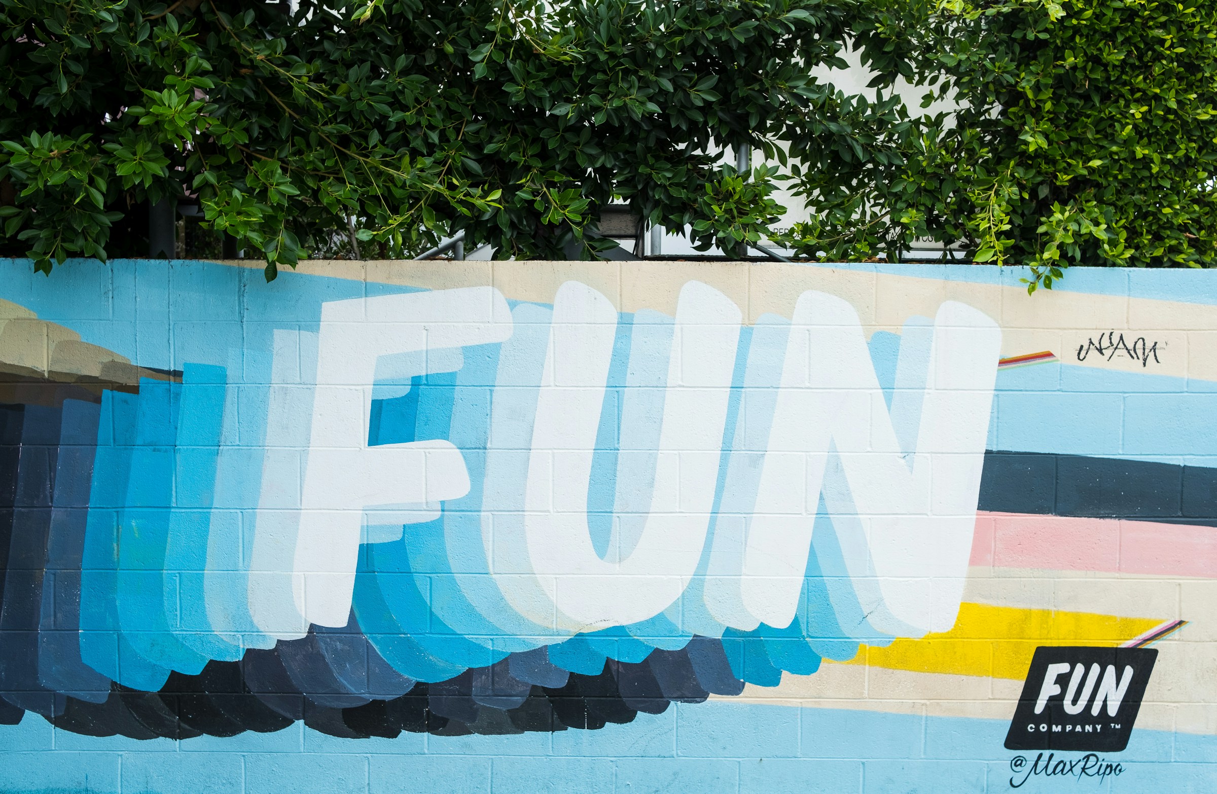A colorful mural on a cement wall with the word