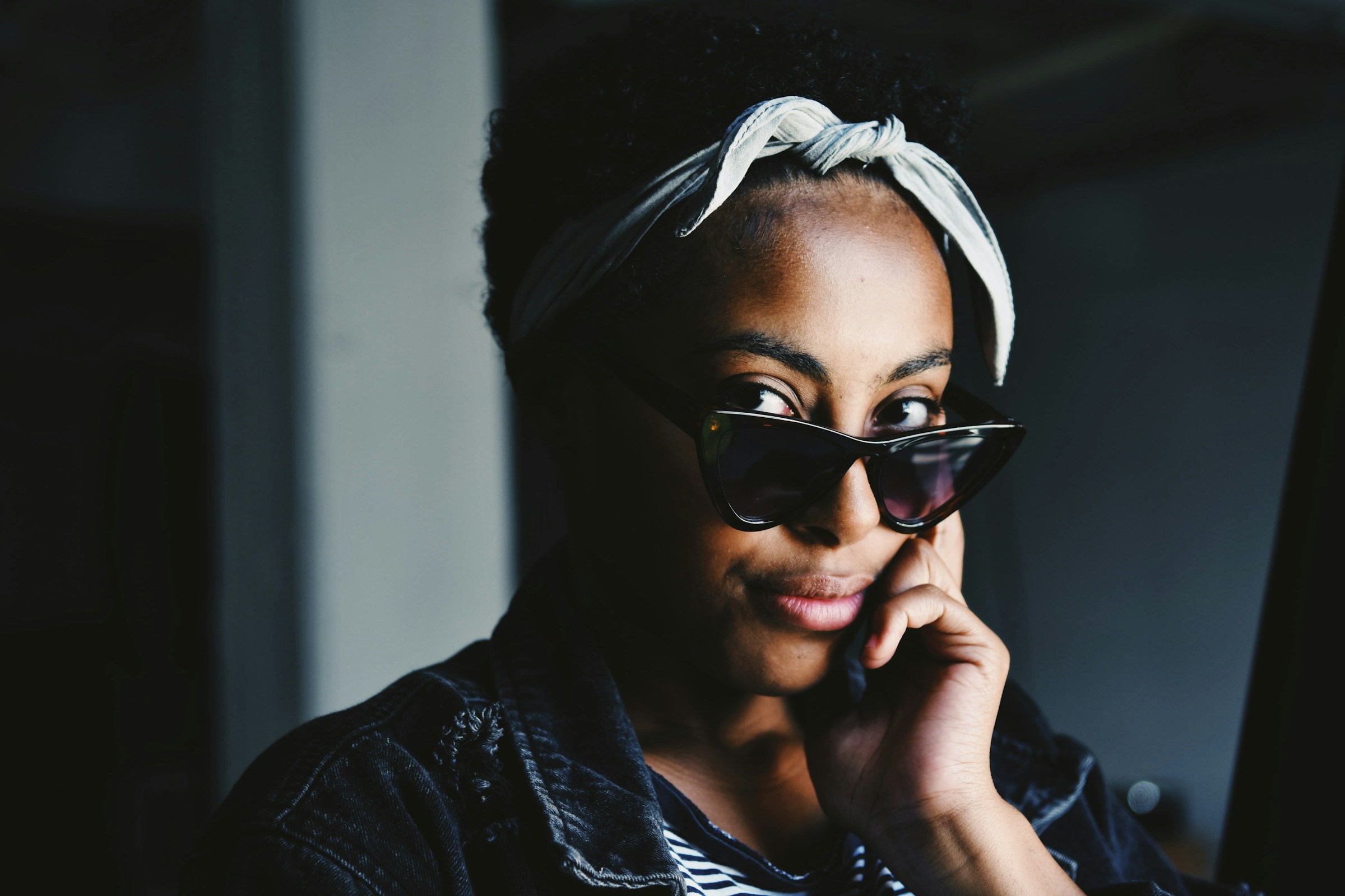 A person looks out over the top of their sunglasses.
