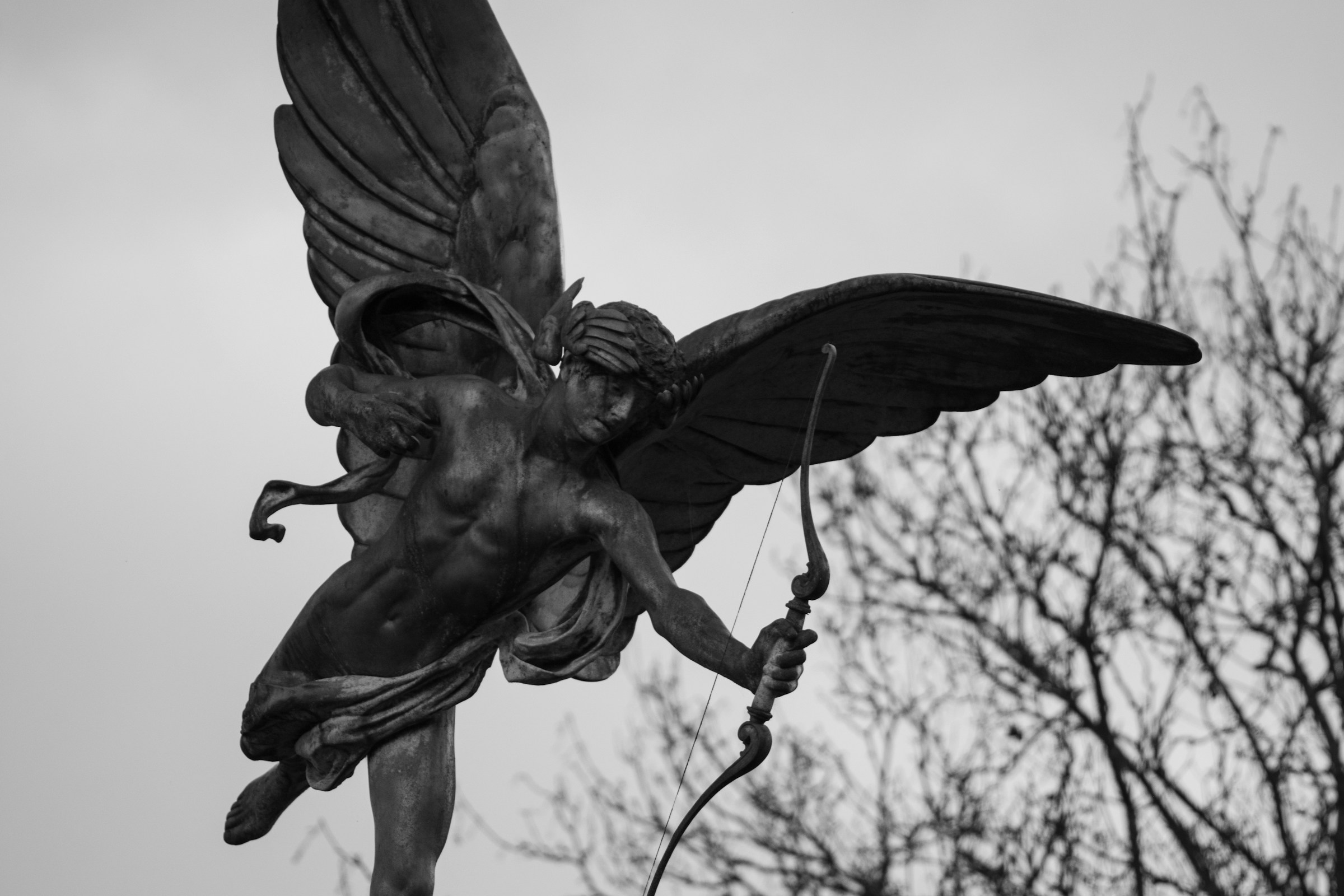 A sculpture of cupid reaching out with his bow.