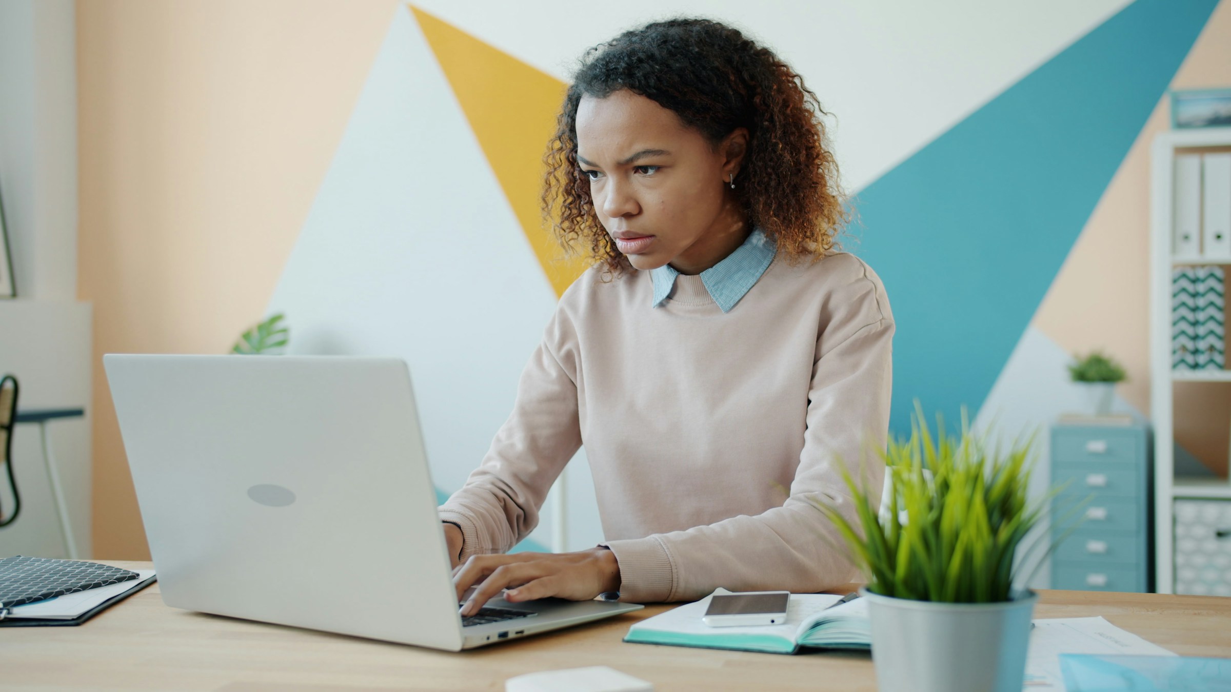 A person looks at computer screen with a confused expression on their face.