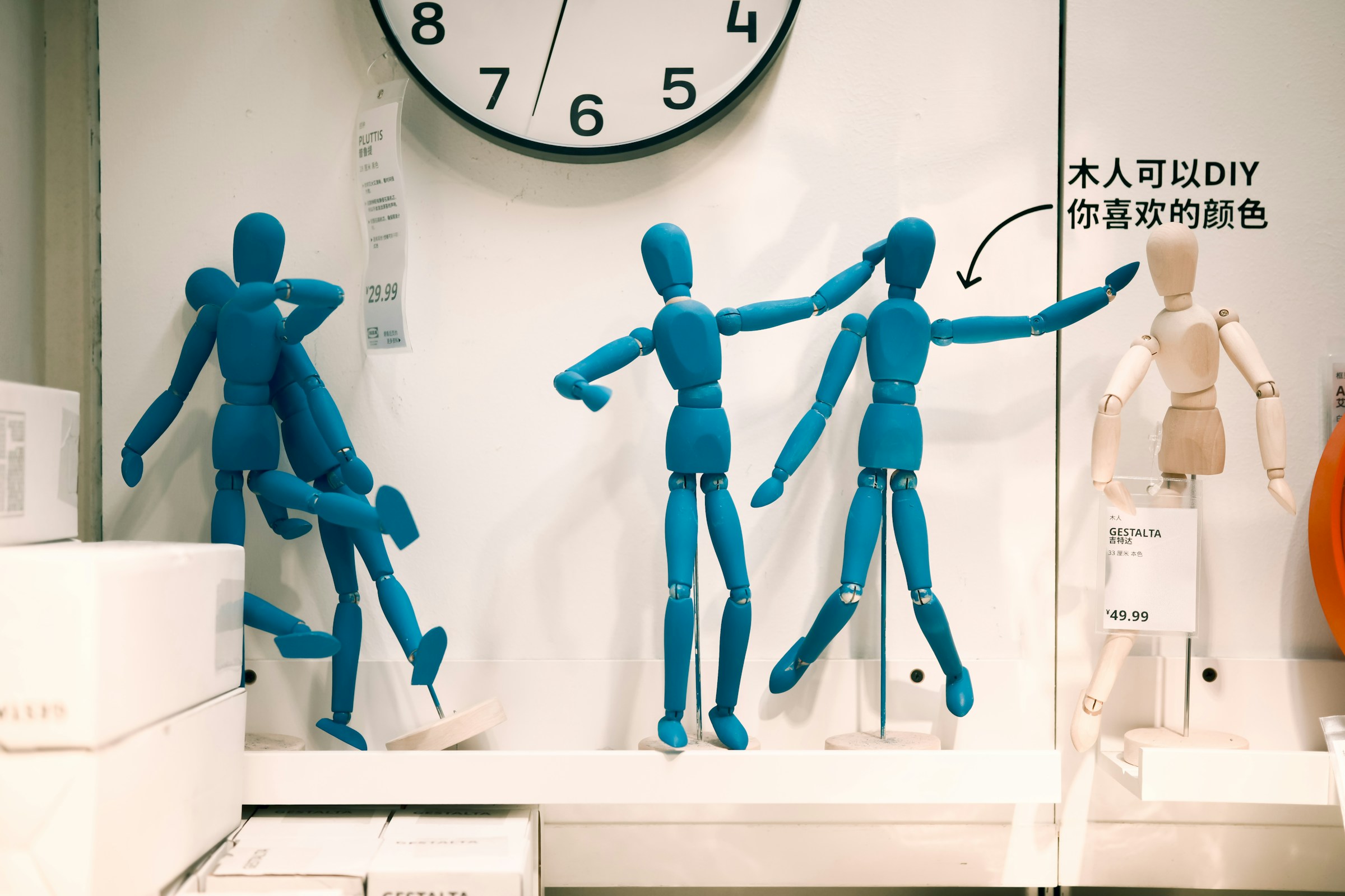 A row of blue artist's figures, one appearing to hit another on the head and two others embracing.