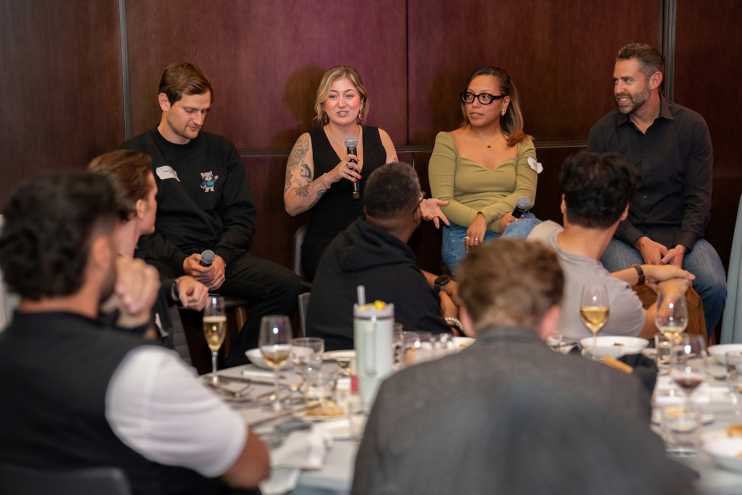 A person speaks into a microphone at an intimate business event.