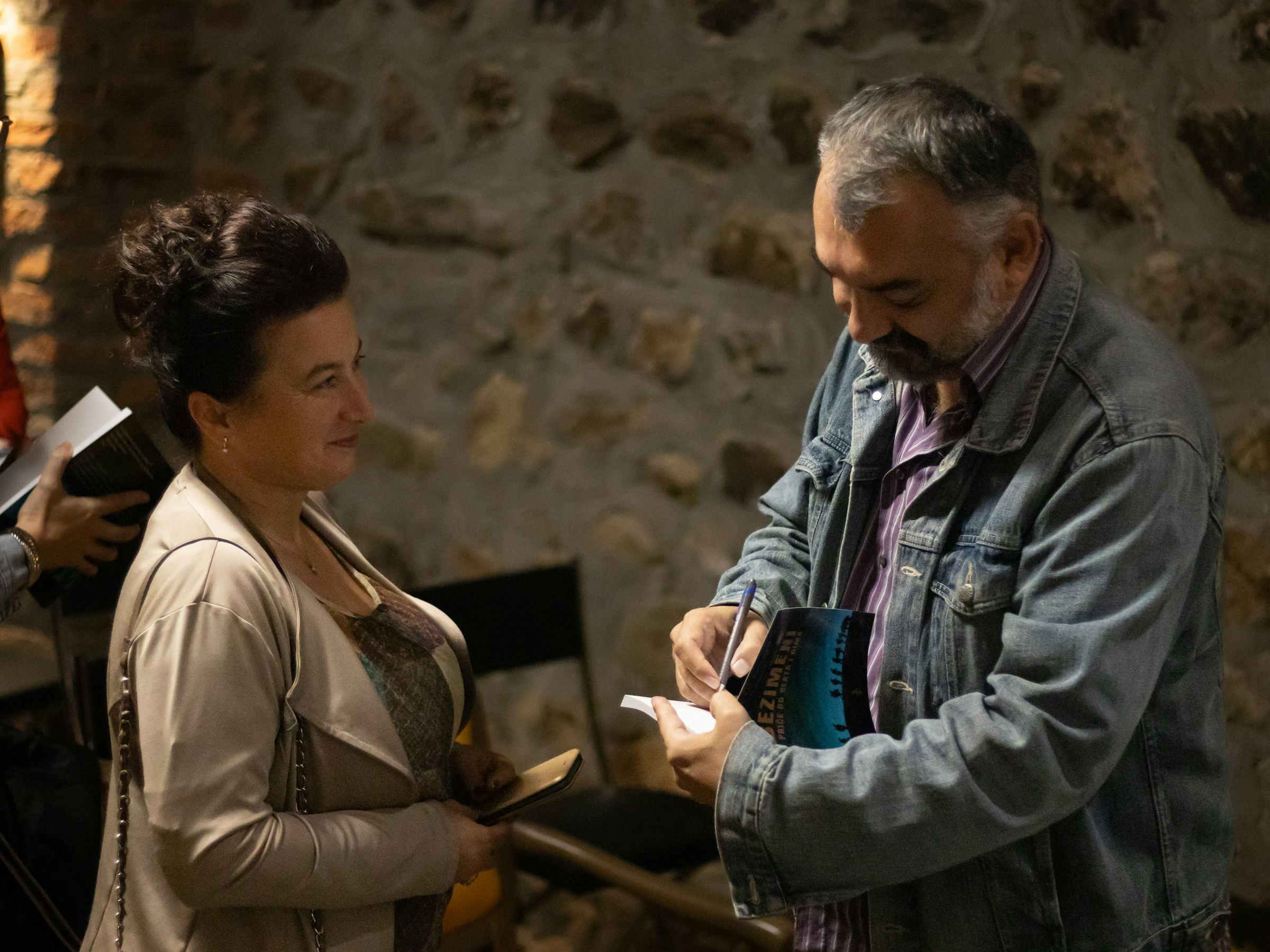 An author signs a book for a reader.